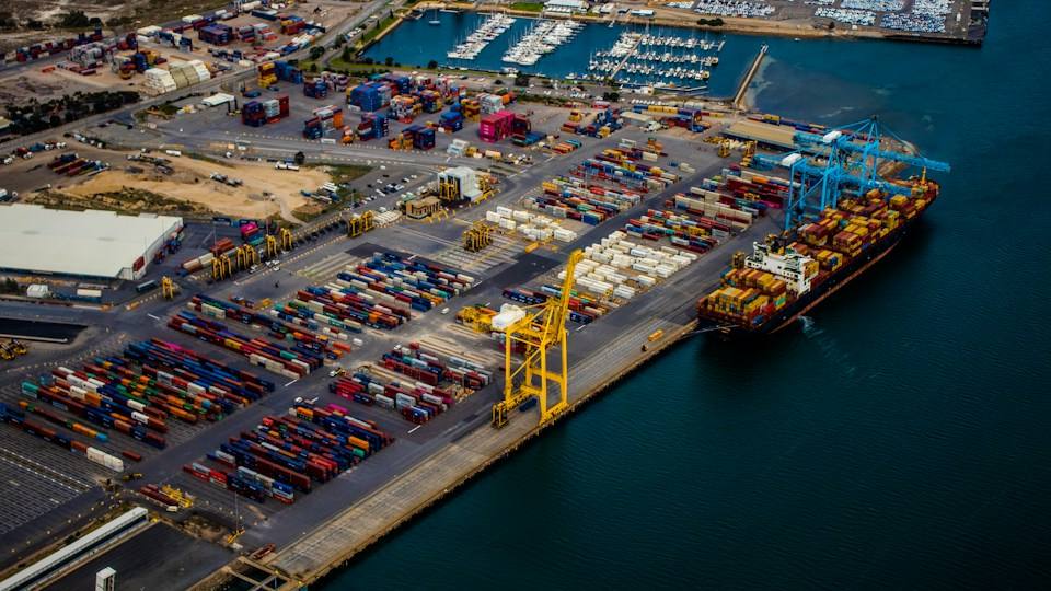 Container cranes and stacked shipping containers at a busy port terminal